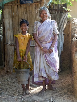 Ursila Bek and her grandaughter Neha Toppo stand beside the new family latrine in the village of Totambi in India's Ranchi District. (UNICEF India Tom Pietrasik 2009)