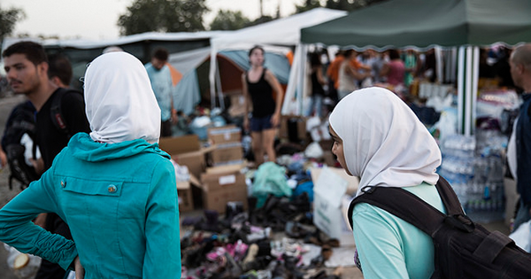Two sisters wait at a transition camp before crossing the border from Greece to FYROM. When a bomb destroyed their house and took the life of their mother and siblings, their father decided to flee Syria and look for safety elsewhere. (International Organization for Migration)