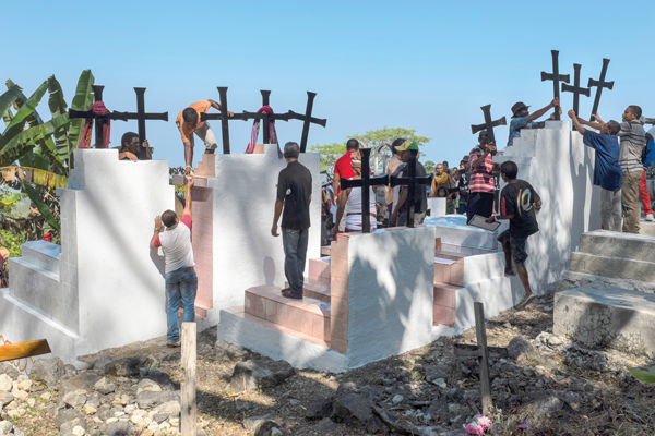 In the mountains above Baguia, Timorese men repair monuments in a cemetery where some of those killed by the Indonesian military are buried.  (Jerry Redfern)