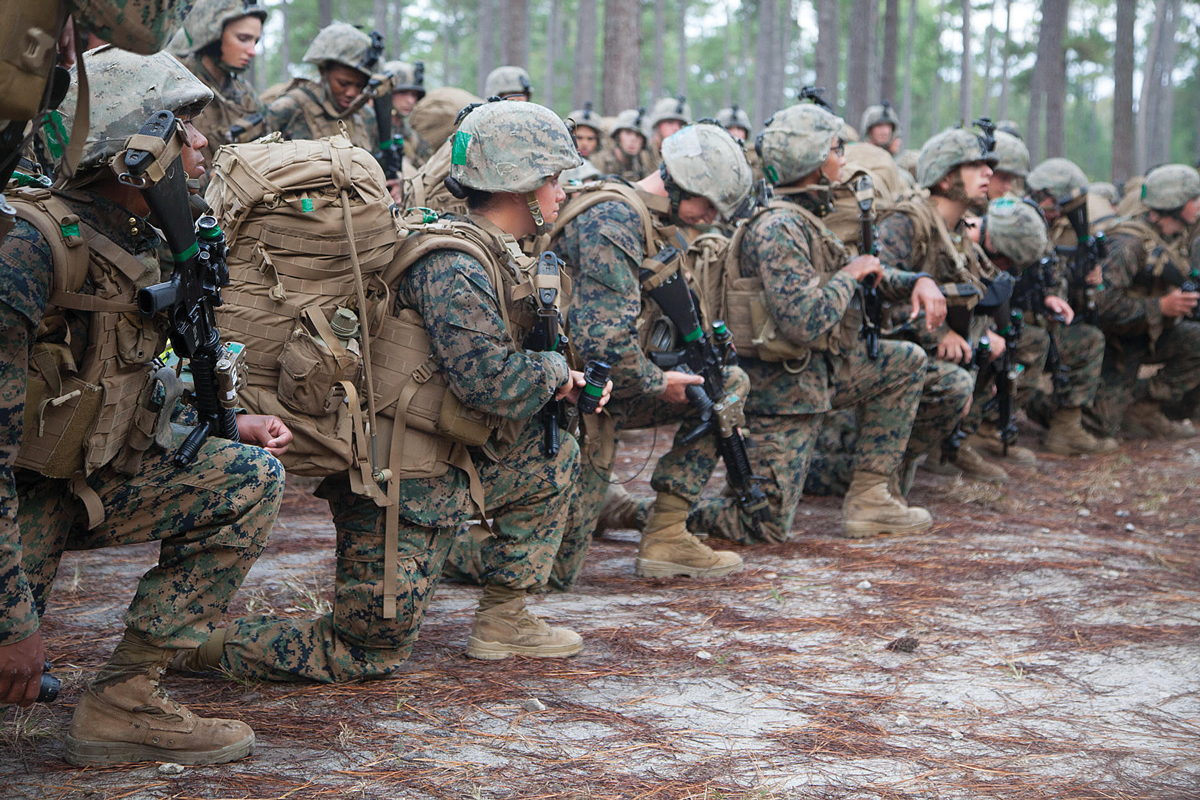 In 2013, a U.S. Marine infantry training unit in North Carolina rests after a 20-kilometer march testing the performance of Marine women. (PFJ Military Collection/ Alamy)