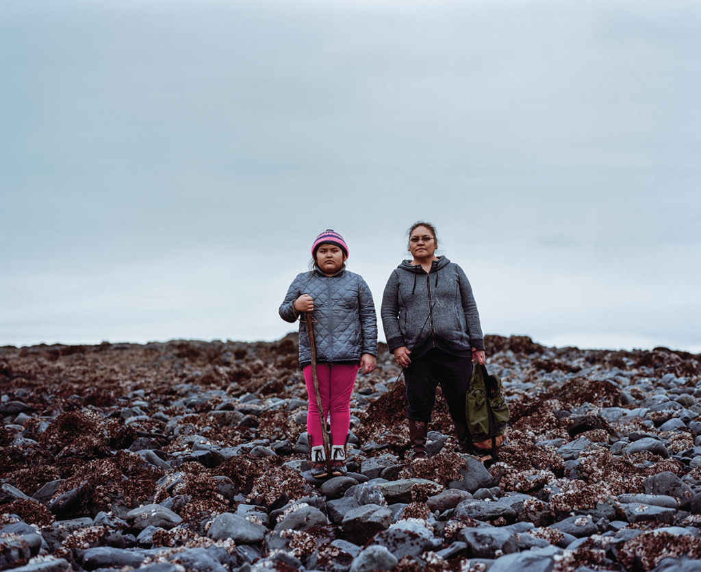 Paula Evans, 11, and her mother, Ann, on the reef at low tide in Nanwalek, where they regularly harvest traditional foods (Ash Adams)