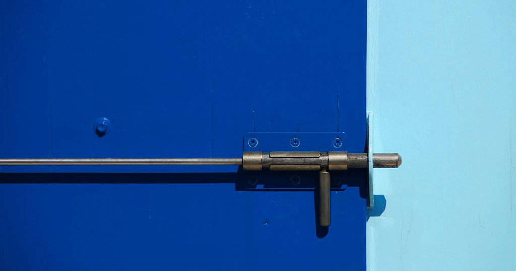 Close-up, abstract photo of a bolted blue door