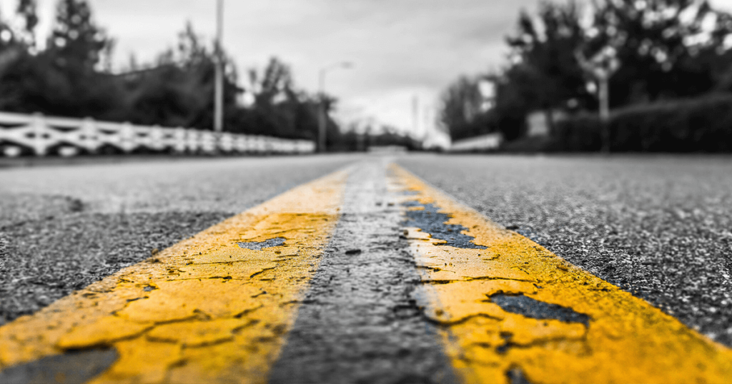 Close-up of the chipped yellow paint on a street lane