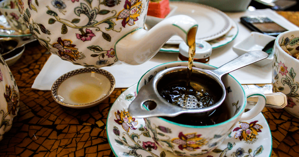 Tea being poured from a colorful floral pot