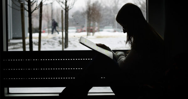 Girl sitting at window reading
