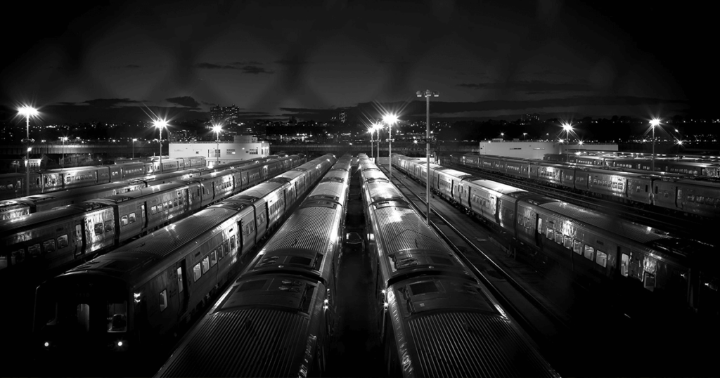 Streetlights shine off a row of trains in the Penn Station depot