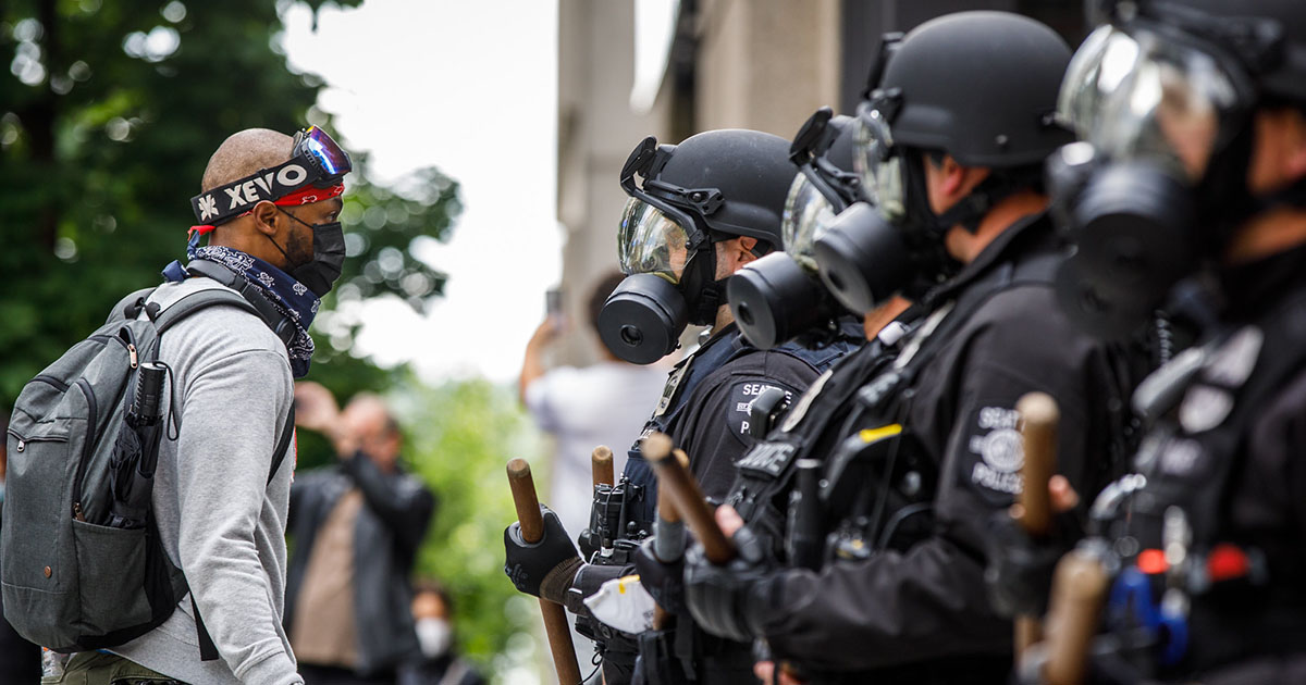 A protestor speaks to a line of Seattle Police Department officers during a Seattle, WA protest against the killing of George Floyd (Derek Simeone, Flickr/dereksimeone)
