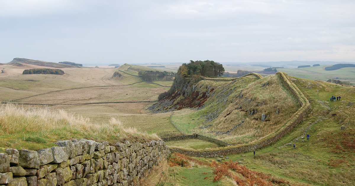 Hadrian’s Wall, a 73-mile barrier built to keep out barbarian tribes, stands “as a testament to survival and adaptation.” (Steven Fruitsmaak/Wikimedia Commons)