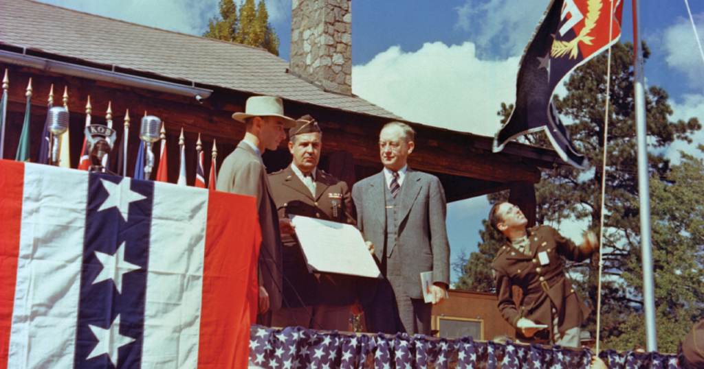 General Leslie Groves (center), head of the Manhattan Project, presents the Army-Navy "E" Award flag to the Los Alamos National Laboratory, October 16, 1945. Lab Director J. Robert Oppenheimer (left) and University of California President Robert Sproul (right) look on. (Flickr/Los Alamos National Laboratory)