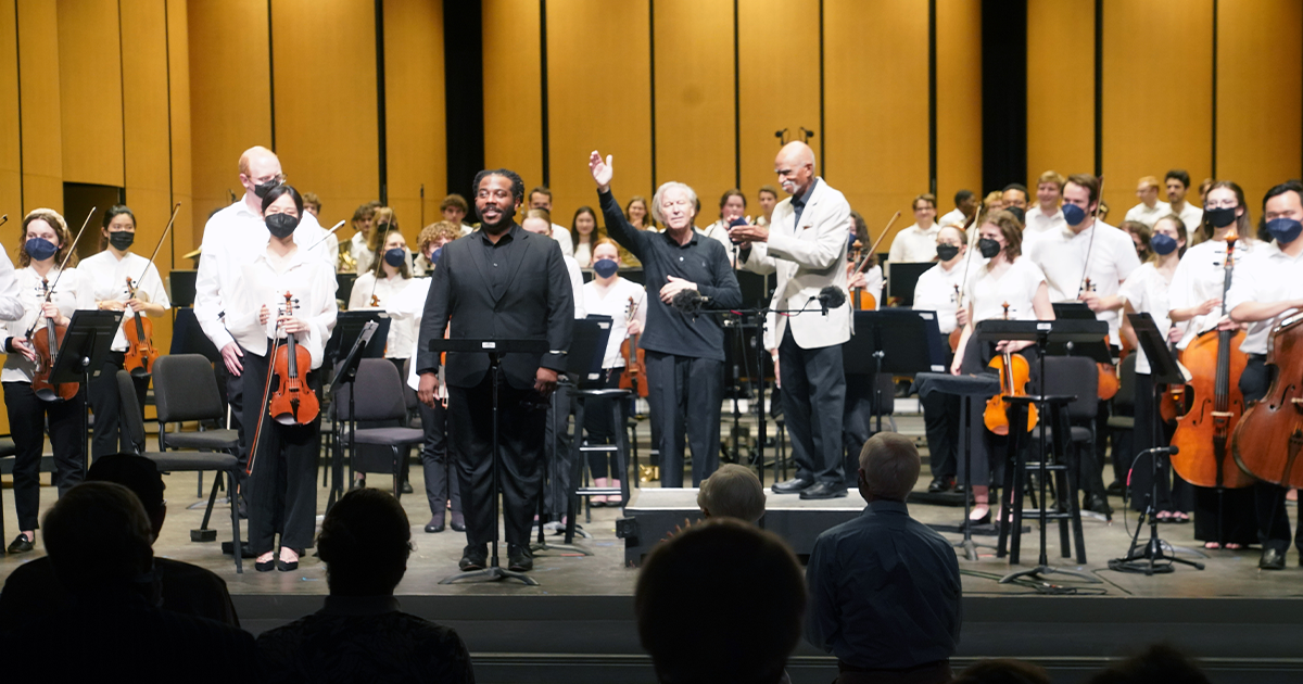 The Brevard Music Center Sinfonia performing on July 15, 2022, with baritone Sidney Outlaw (center left), conductor Angel Gil-Ordoñez, and tenor George Shirley (on the podium) (Mark Clague)